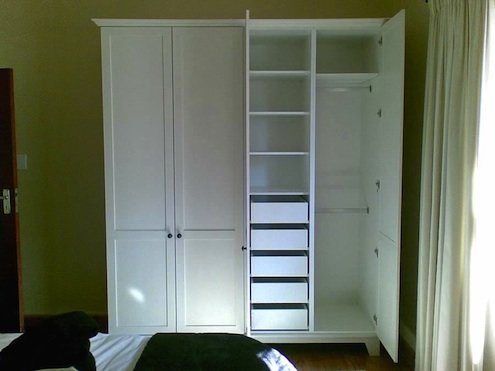 Armoire blanche indépendante avec tiroirs de rangement intégrés.