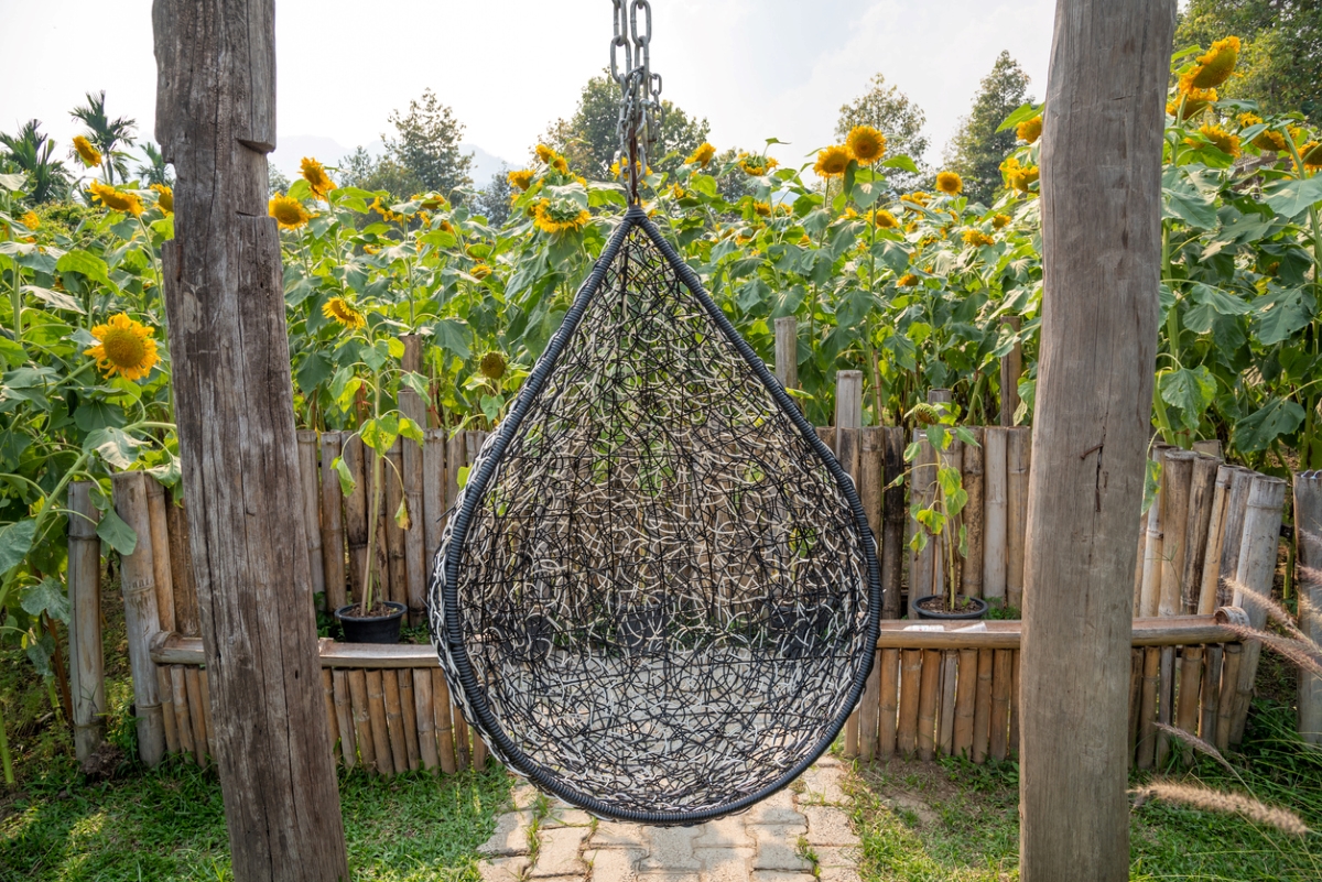 Garden hammock seat with sunflowers in background