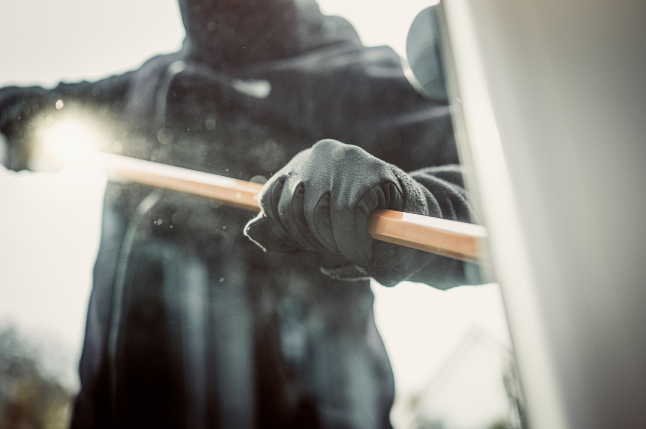 security window film burglar in black using crowbar to break window