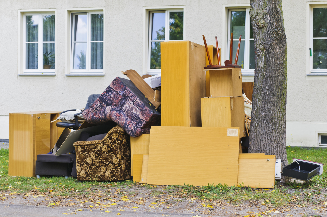 Un trottoir d’une maison rempli de meubles d’occasion.