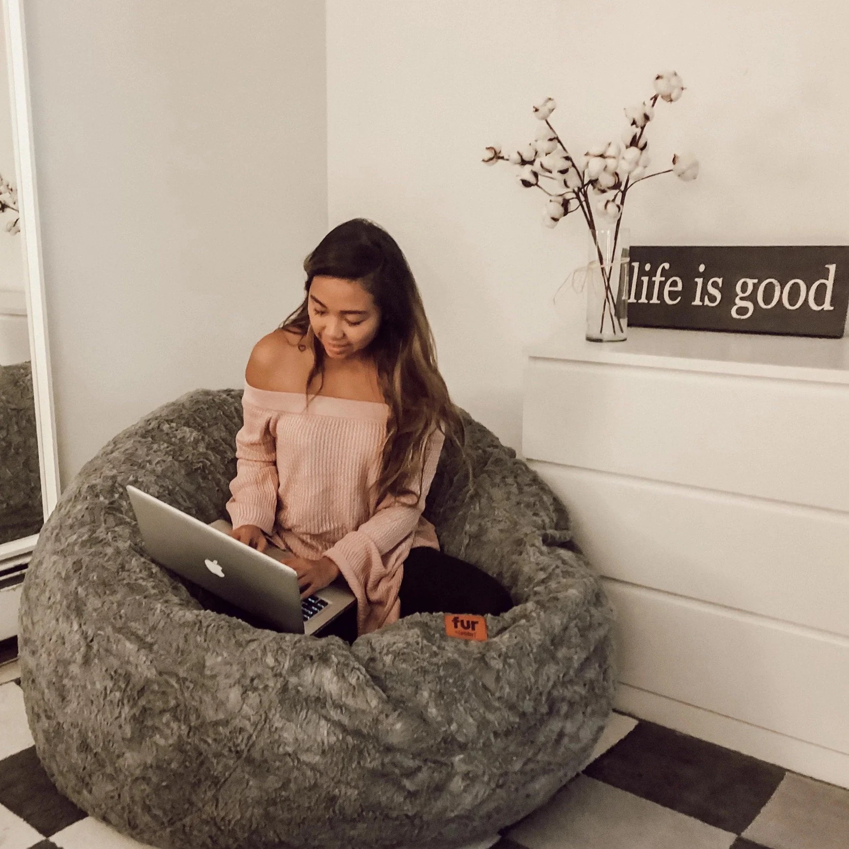 Woman with laptop on cordaroys beanbag