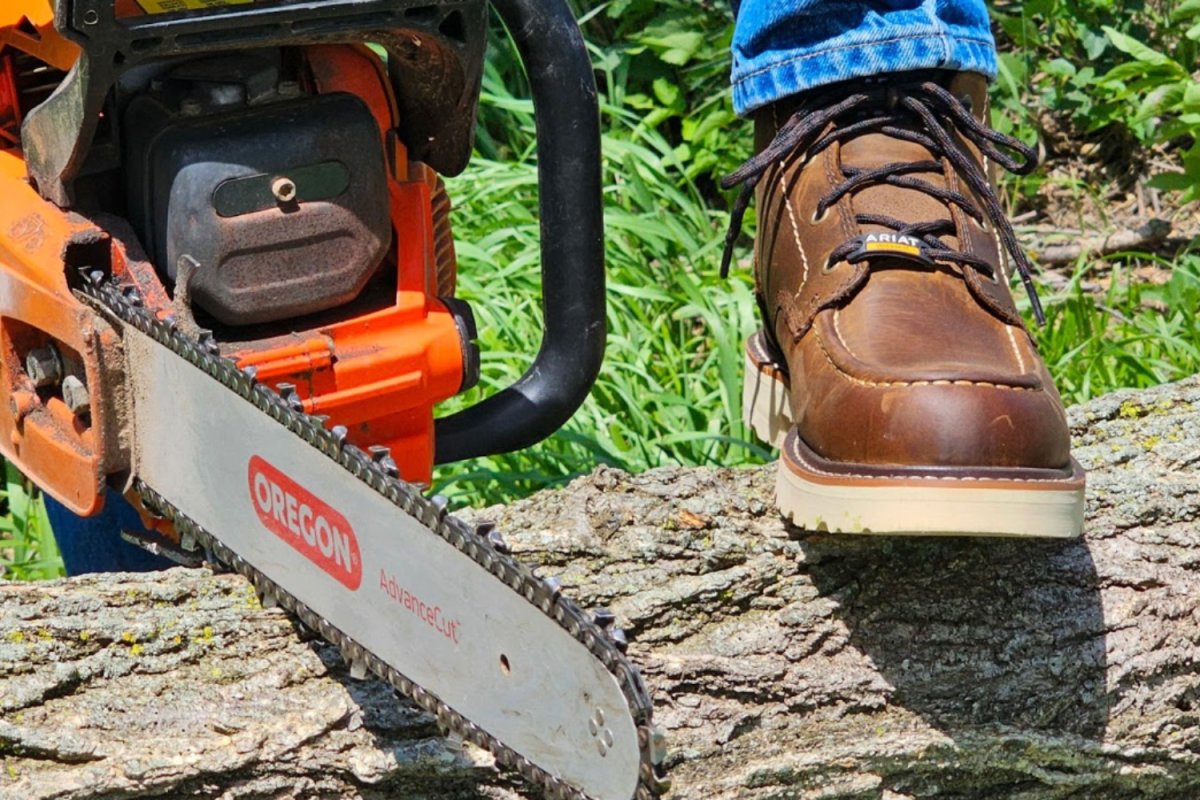 Person stepping on log in brown Ariat Rebar Lift work boots with chainsaw