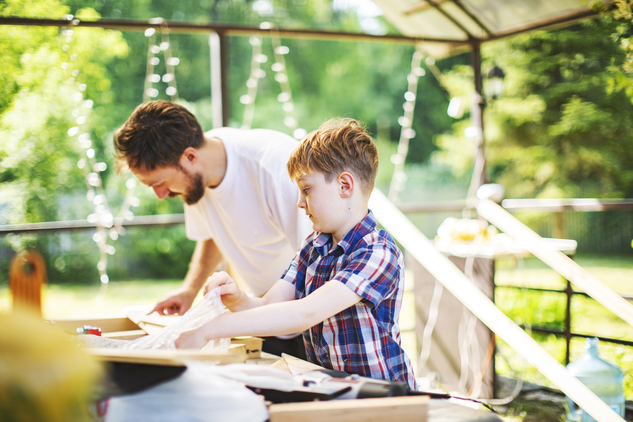 Father and son building tree house at backyard