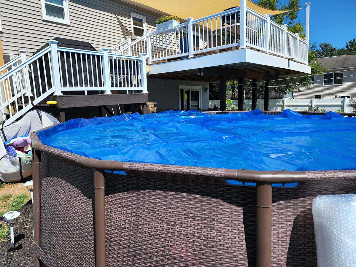 Above ground pool with a blue pool cover on the top