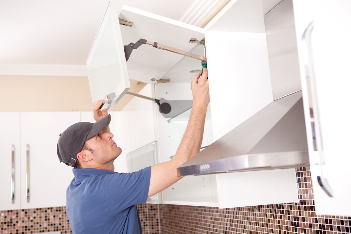 Man installing upper wall cabinet