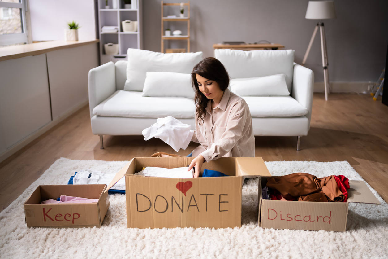 femme dans le salon triant ses affaires pour les donner