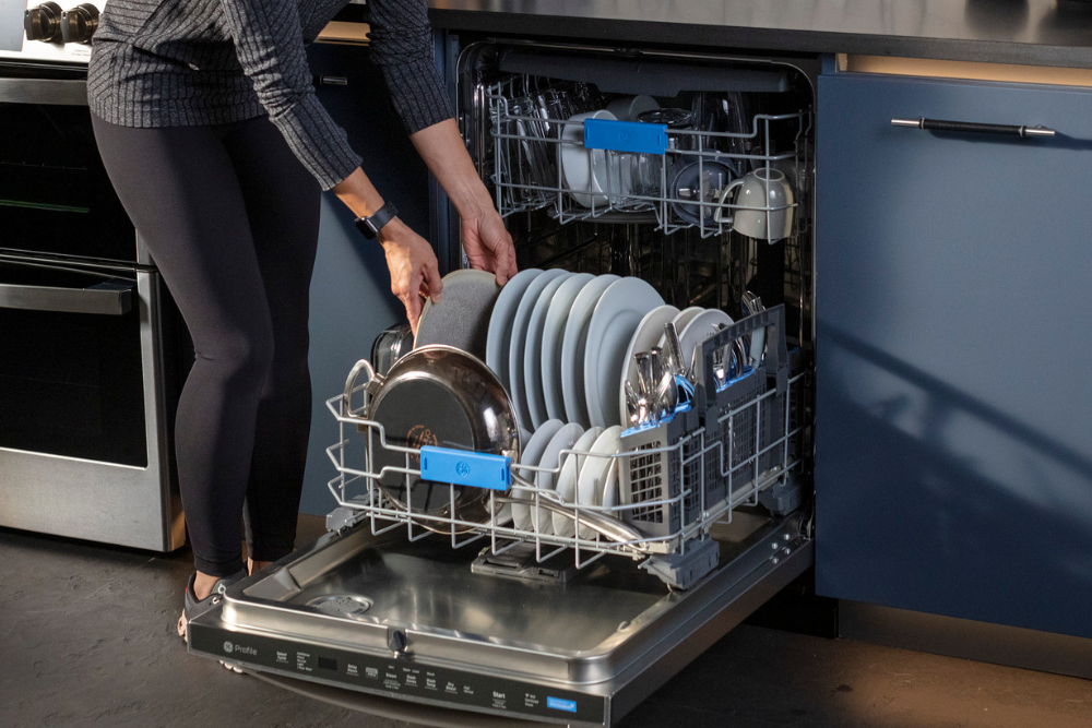 Someone loading a dishwasher in a kitchen