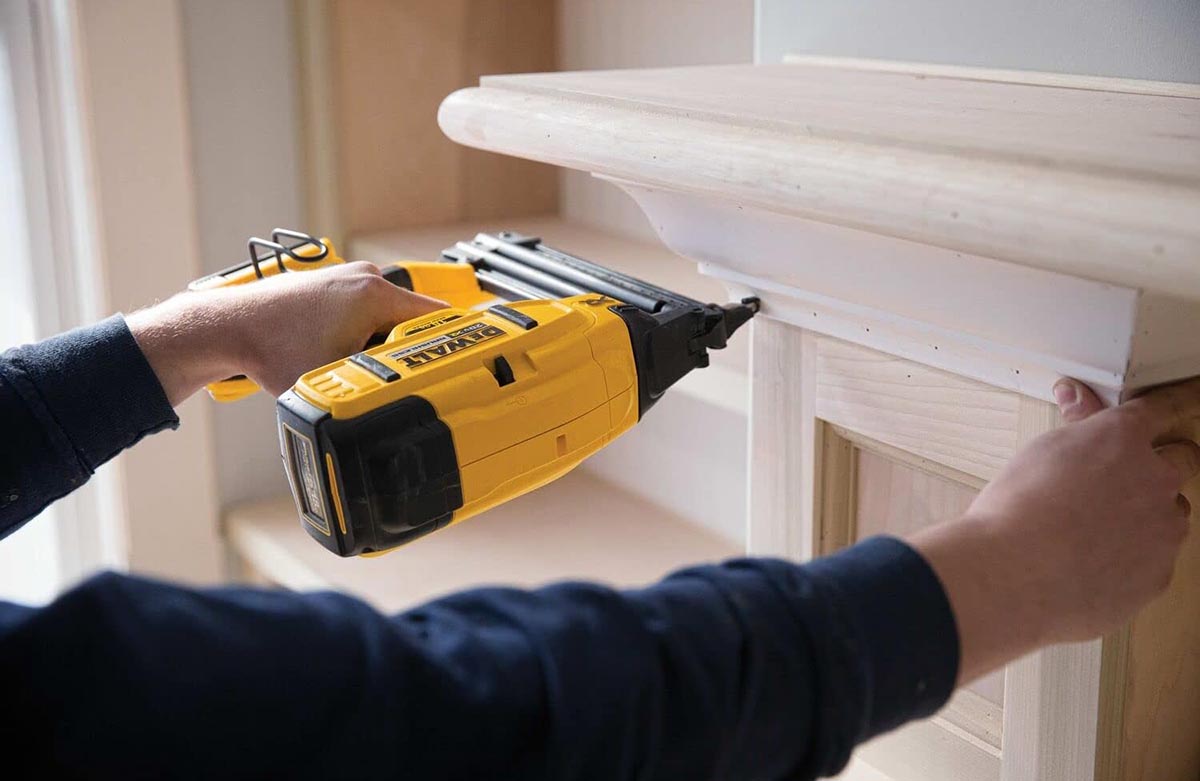 A person using the best DeWalt cordless brad nailer to attach trim