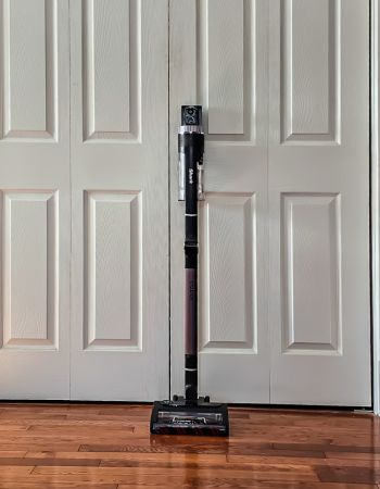 L'aspirateur sans fil Dyson Outsize appuyé contre les portes du placard avant le test comparatif entre Dyson et Shark.