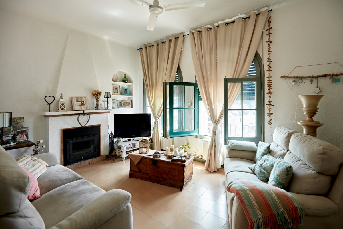 Comfortable living room with sofas fireplace and floor to ceiling drapes