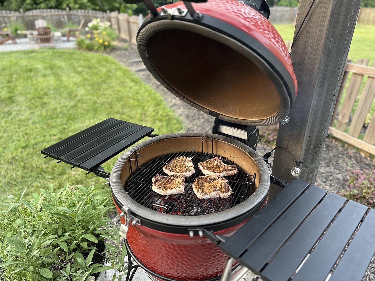 The Kamado Joe Classic Joe grill open with meat cooking