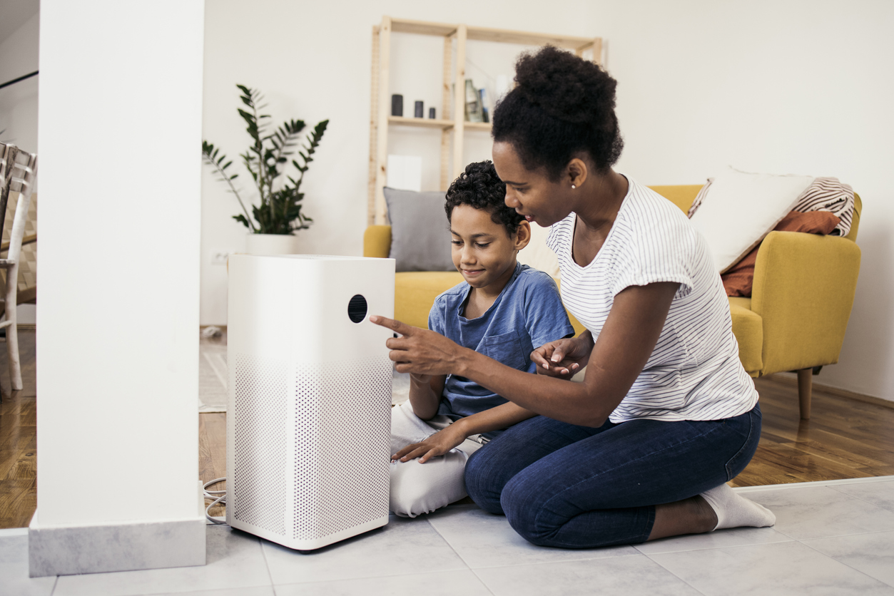 Une femme afro-américaine et son fils configurent le système de maison intelligente sur un smartphone.