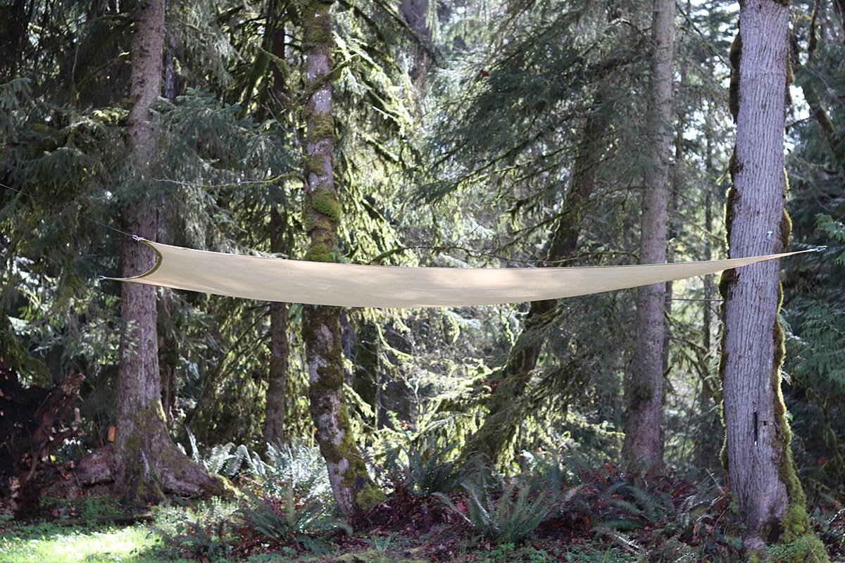 The Best Shade Sail installed between large pine trees during testing.