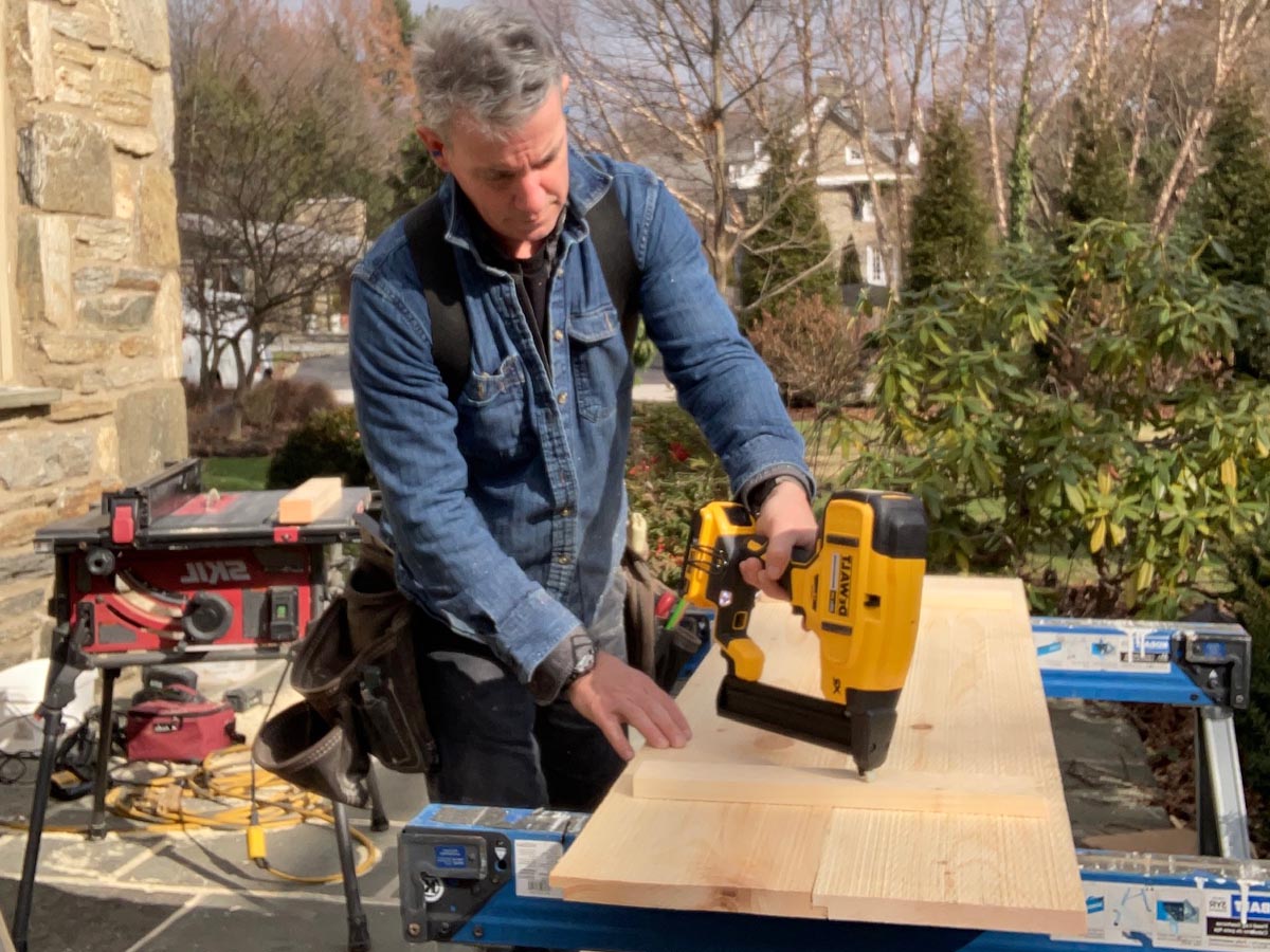 A person using the DeWalt Crown Stapler to fasten a piece of wood during a hands-on test.