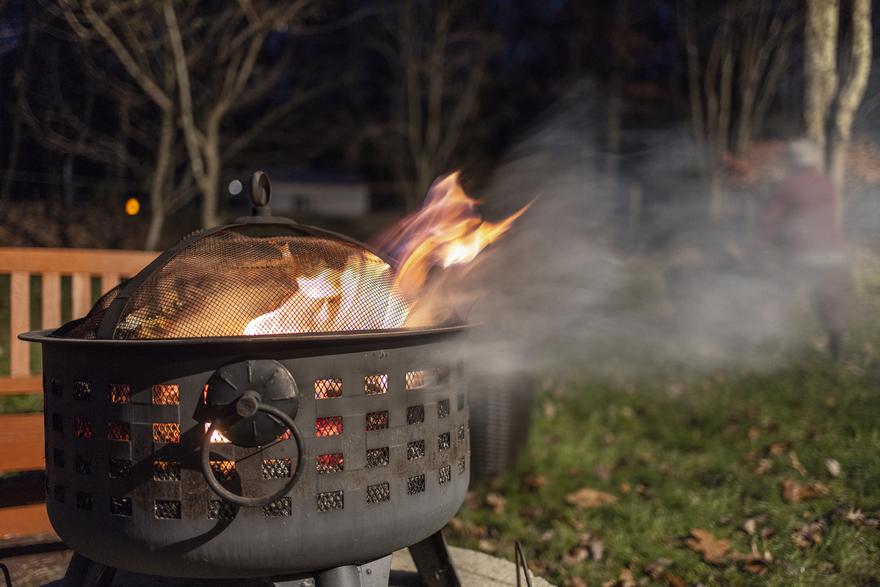 Burning old leaves in the fire pit outside the house.