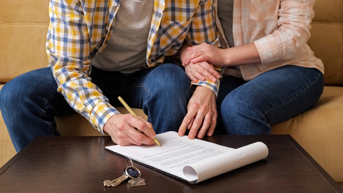 Couple signant un bail avec les clés sur la table