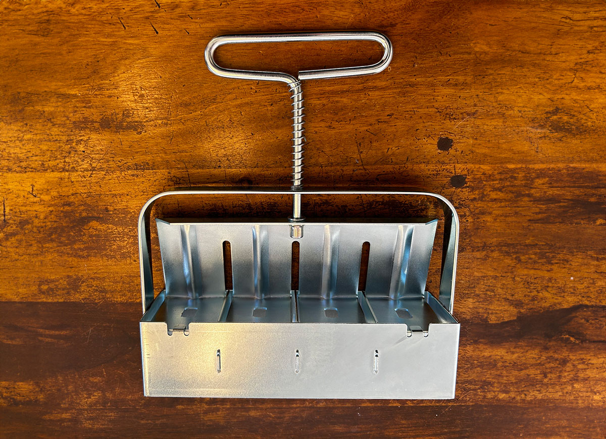 A soil blocker on a kitchen table waiting to be used for starting seeds for early spring gardening.