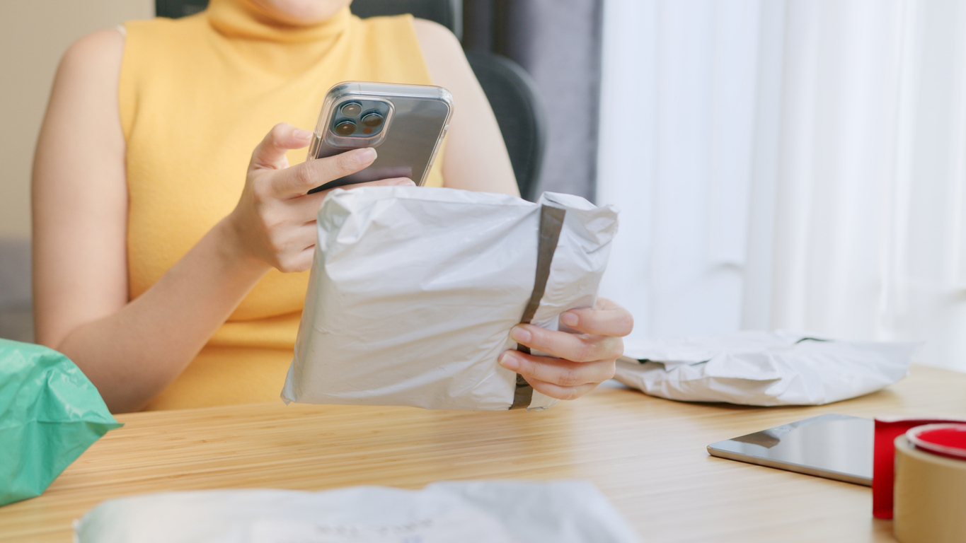 iStock-1363972995 things you never knew about returns woman Using smart phone scanning QR code or barcode on package