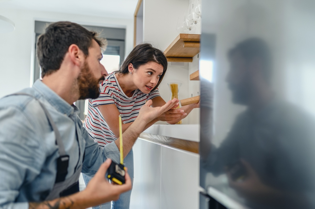 Young couple repair a refrigerator. 