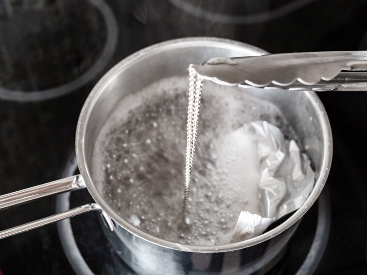 Using tongs to move silver chain from solution