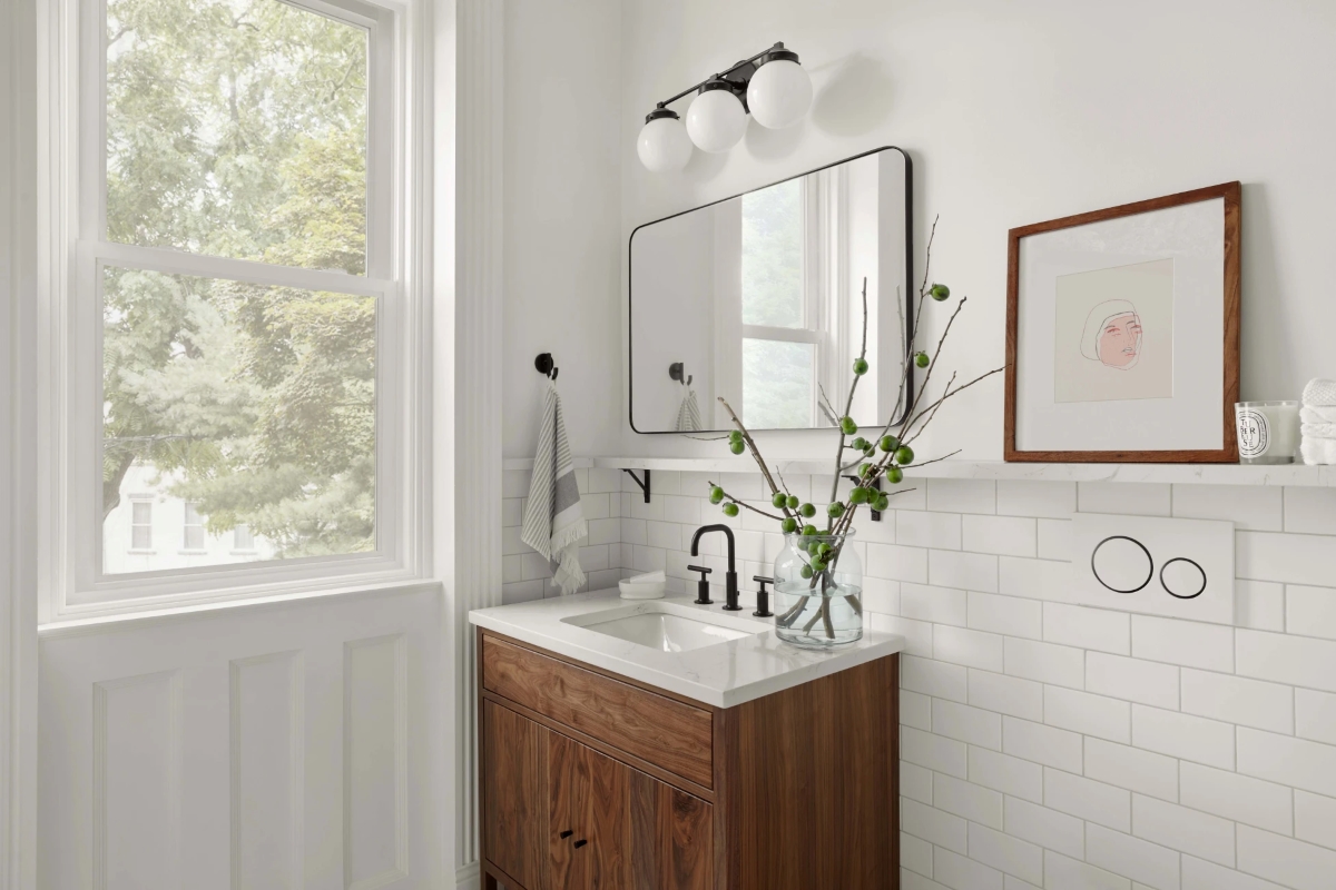 White bathroom with plant in clear vase.