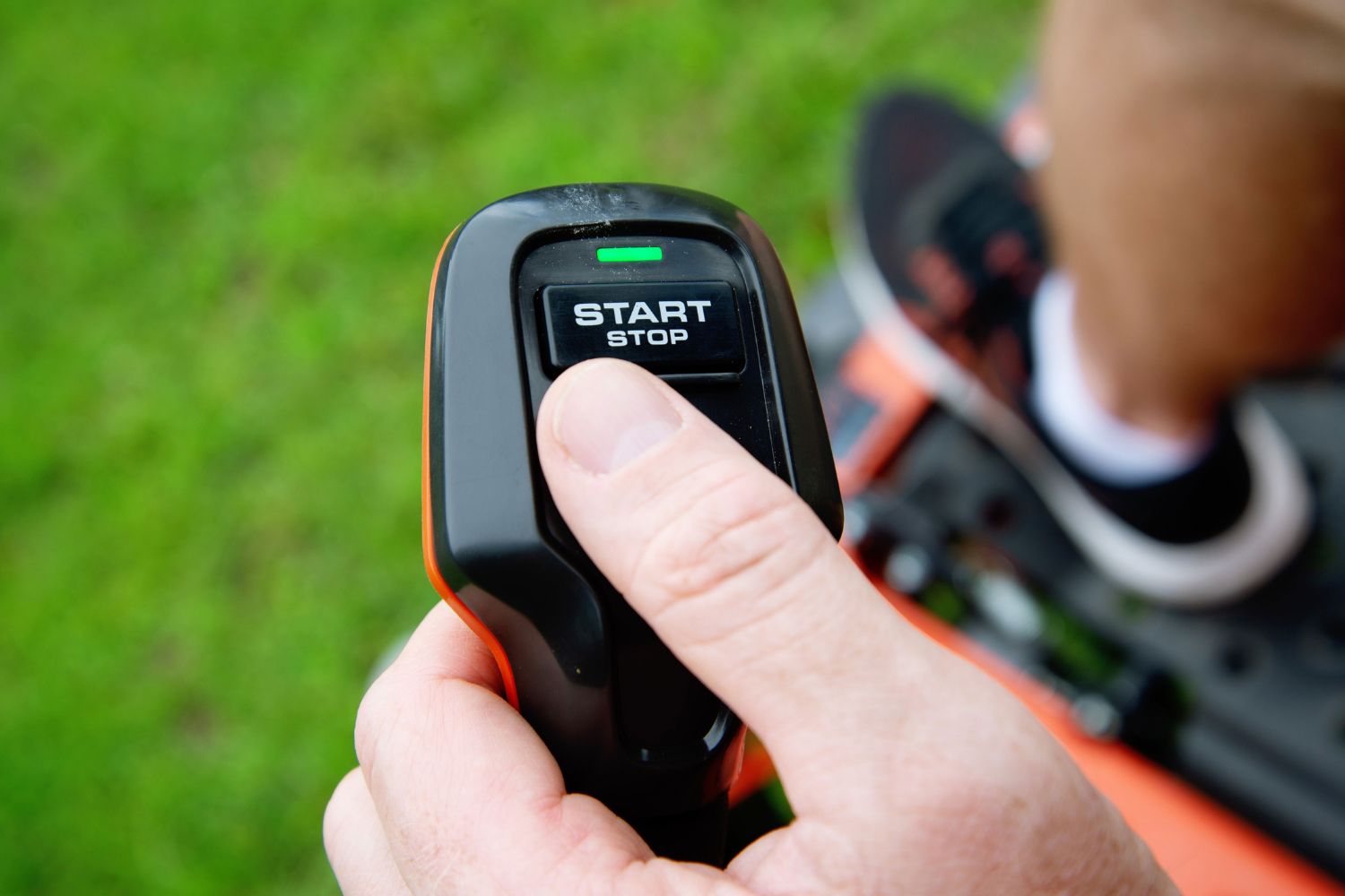 A person pressing the start button on the Husqvarna XCite 350 zero turn riding mower