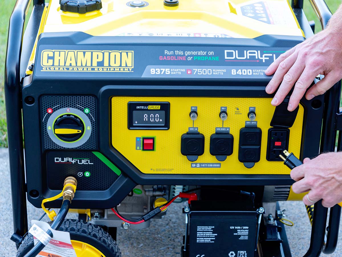 Person plugging in an appliance into a Champion 7500 propane generator