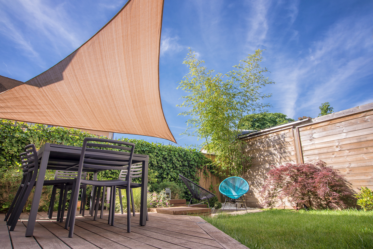 Terrasse d'une maison moderne en été avec table et voile d'ombrage