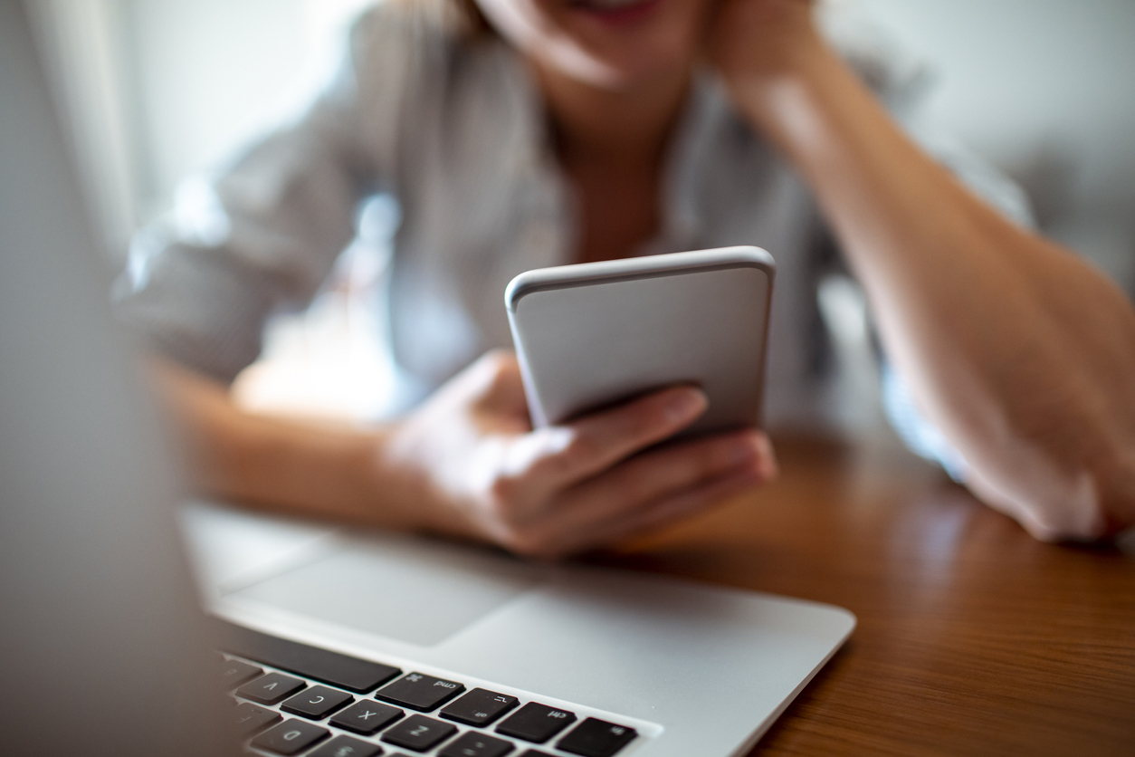 iStock-1187536032 video doorbell woman checking iphone