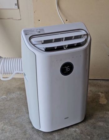 White Dreo portable air conditioner on concrete garage floor