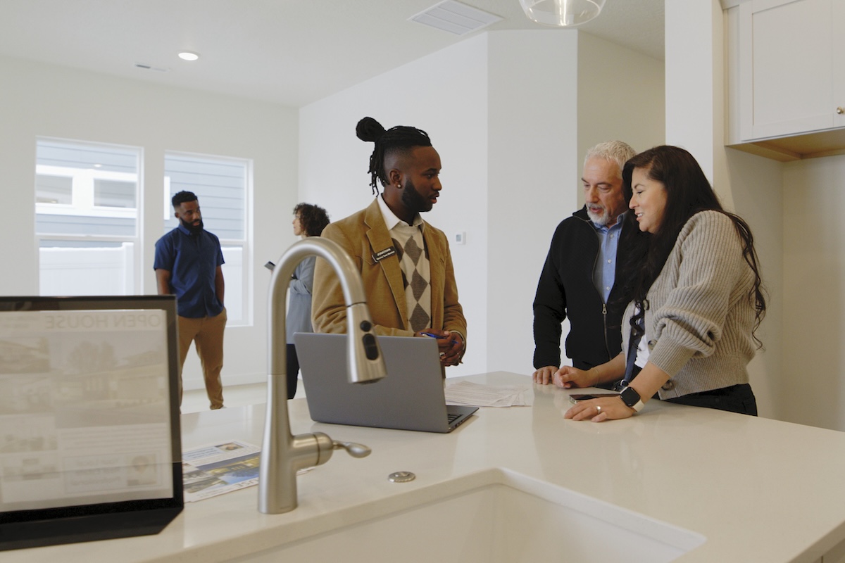 Real estate agent helping a couple at open house.