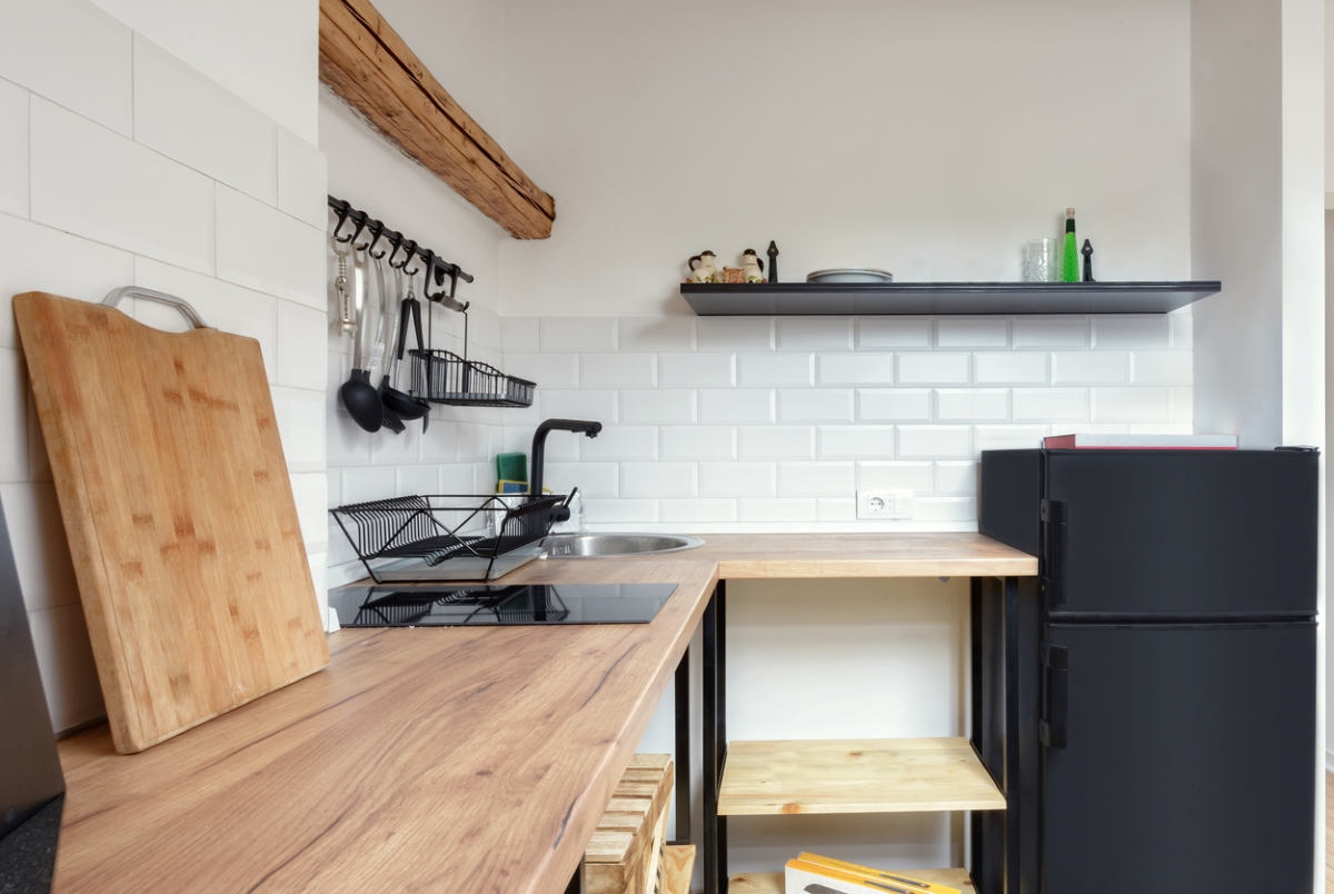 Small corner kitchen with wood table top.