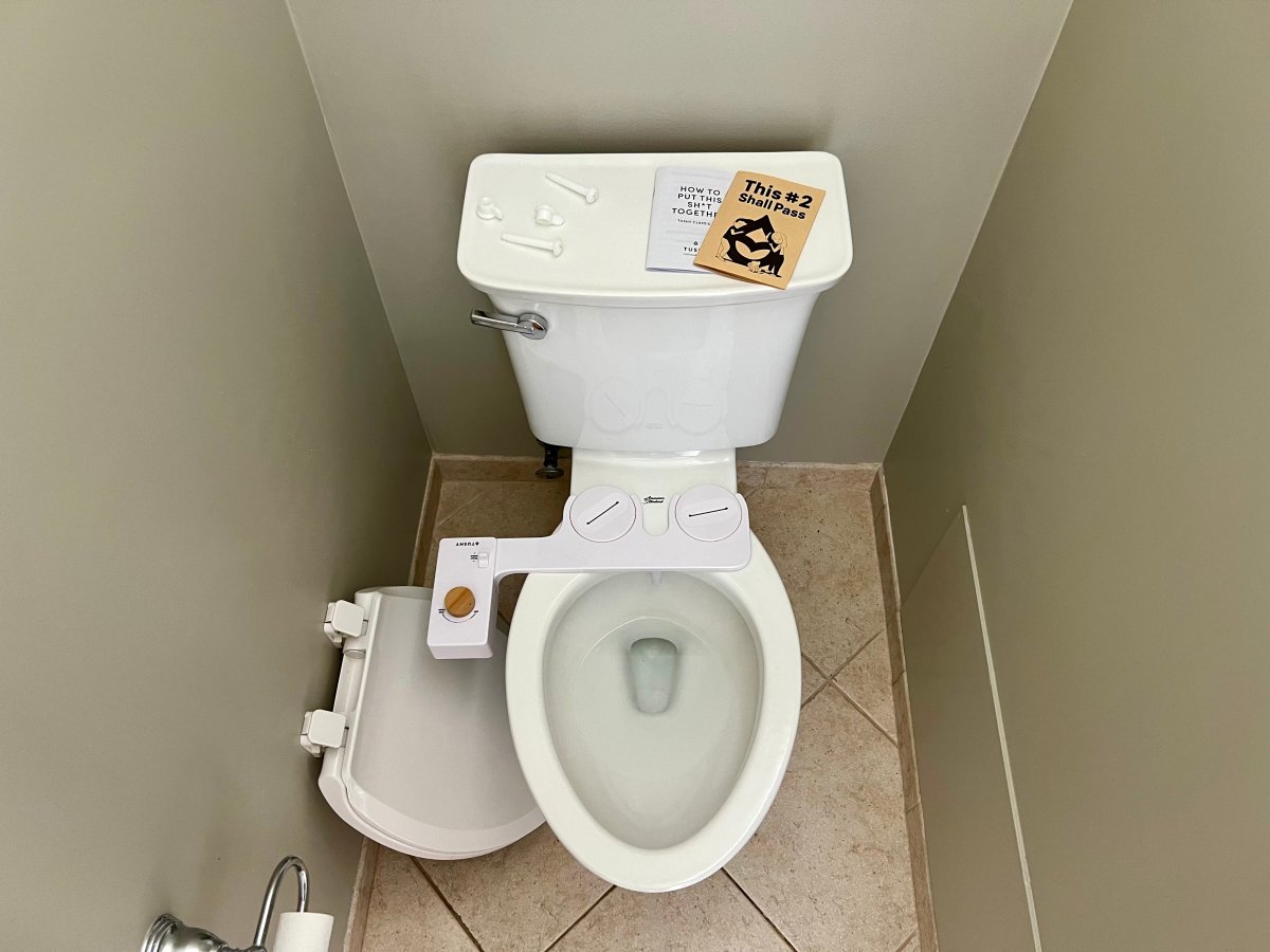 Tushy Bidet placed on a white toilet about to be installed