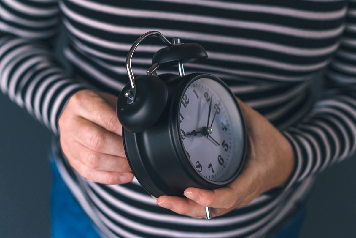 daylight savings time 2023 - woman winding clock