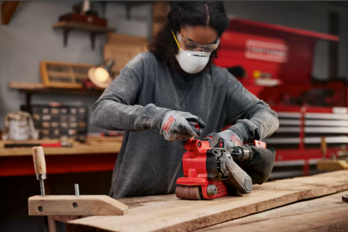 Femmes utilisant une ponceuse Craftsman sur un morceau de bois 