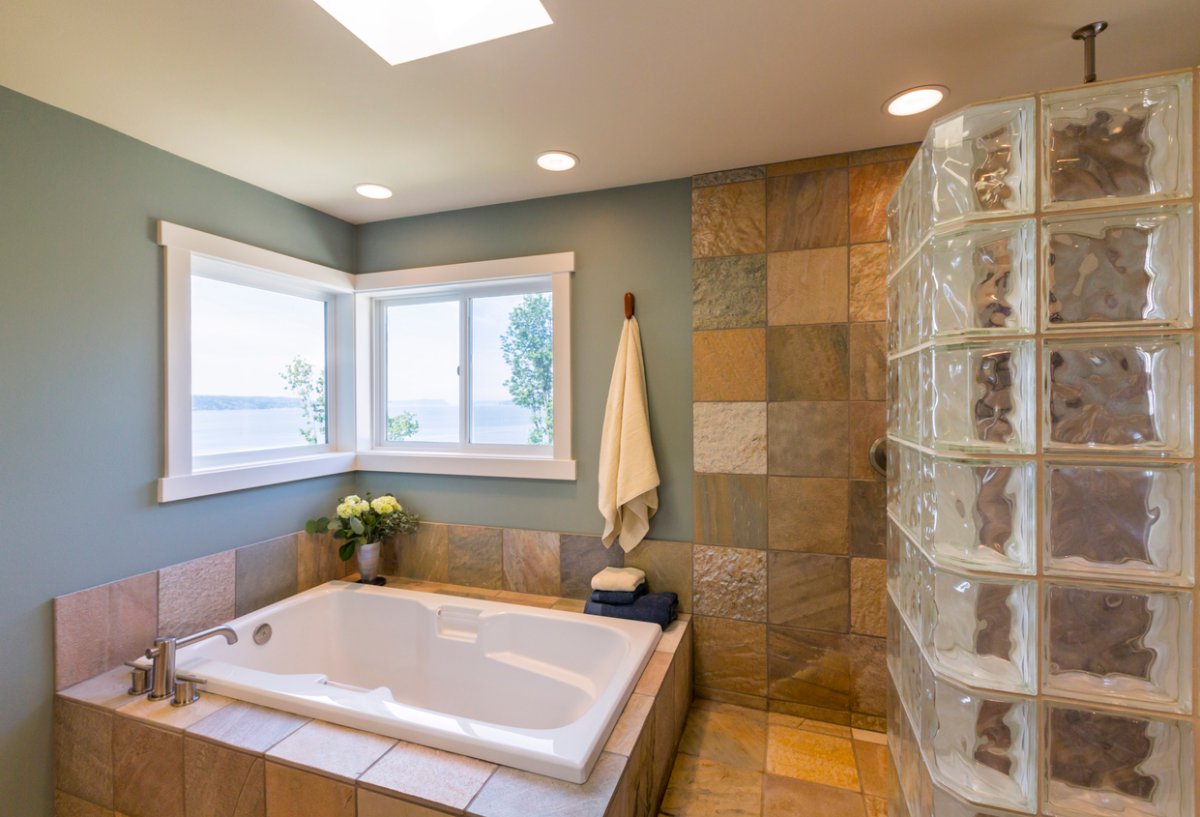 nice modern bathroom with jacuzzi tub and a wall of glass block windows