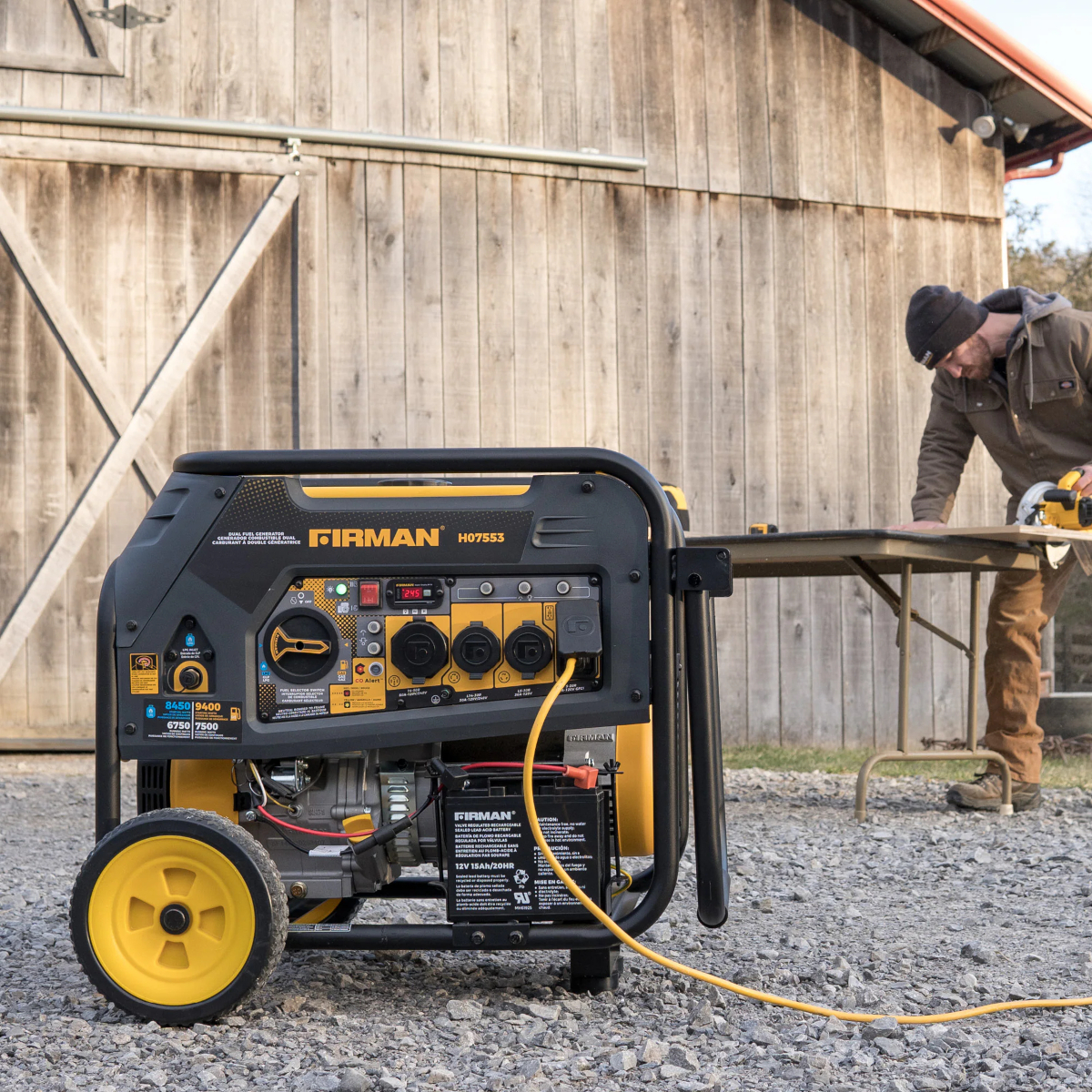 A Firman 7500-Watt Dual Fuel generator sits outside of a rural barn where it is powering a circular saw.