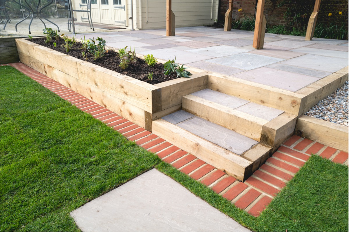 Several raised garden beds in a backyard patio.