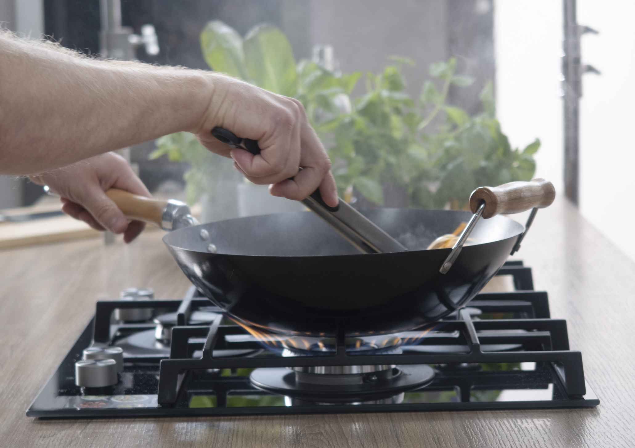 Frying pan on a gas stove. Chef controls the cooking process.cooking on a gas stove. expensive gas in Europe.