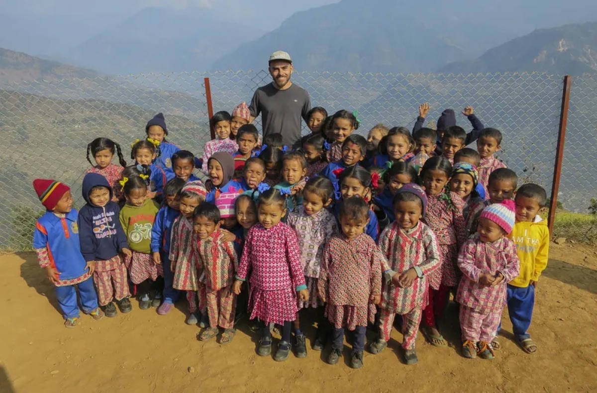 Un homme avec des enfants de la communauté locale