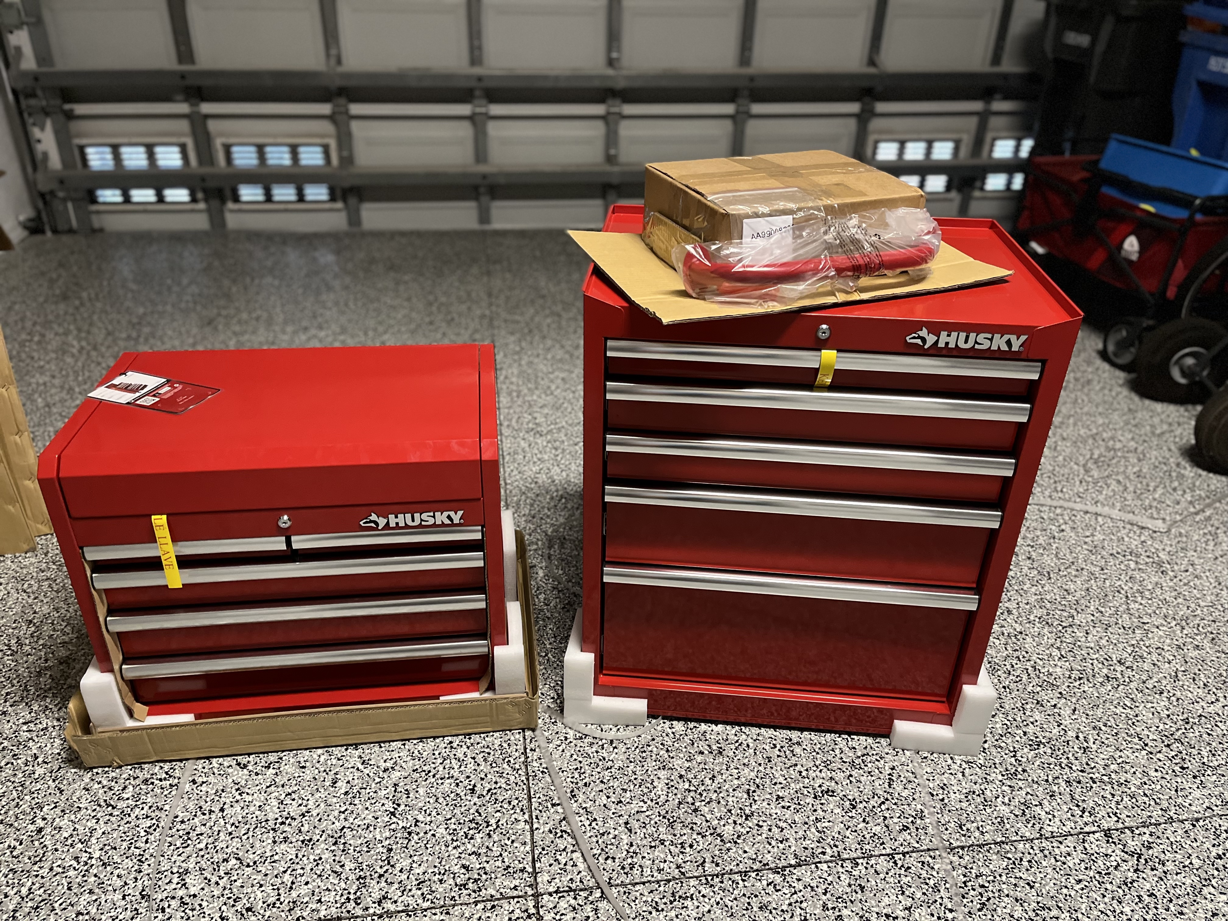 The Husky 10-Drawer Tool Chest and Cabinet Combo on a garage floor before assembly and testing.