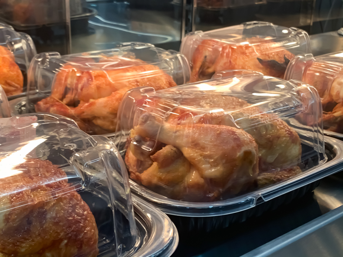 Poulet rôti emballé placé sur l'étagère en attendant la vente dans la section charcuterie du marché