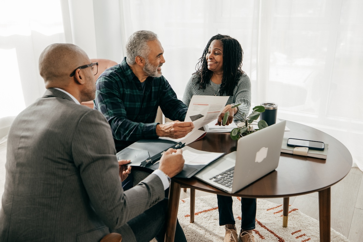 A couple sitting at a table with a tax professional learning about homeowner tax deductions.