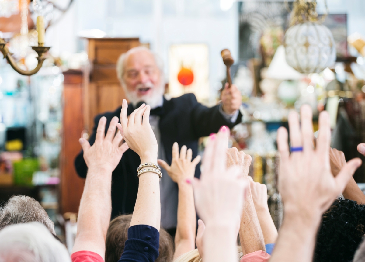 Multiple raised hands in front of auctioneer.