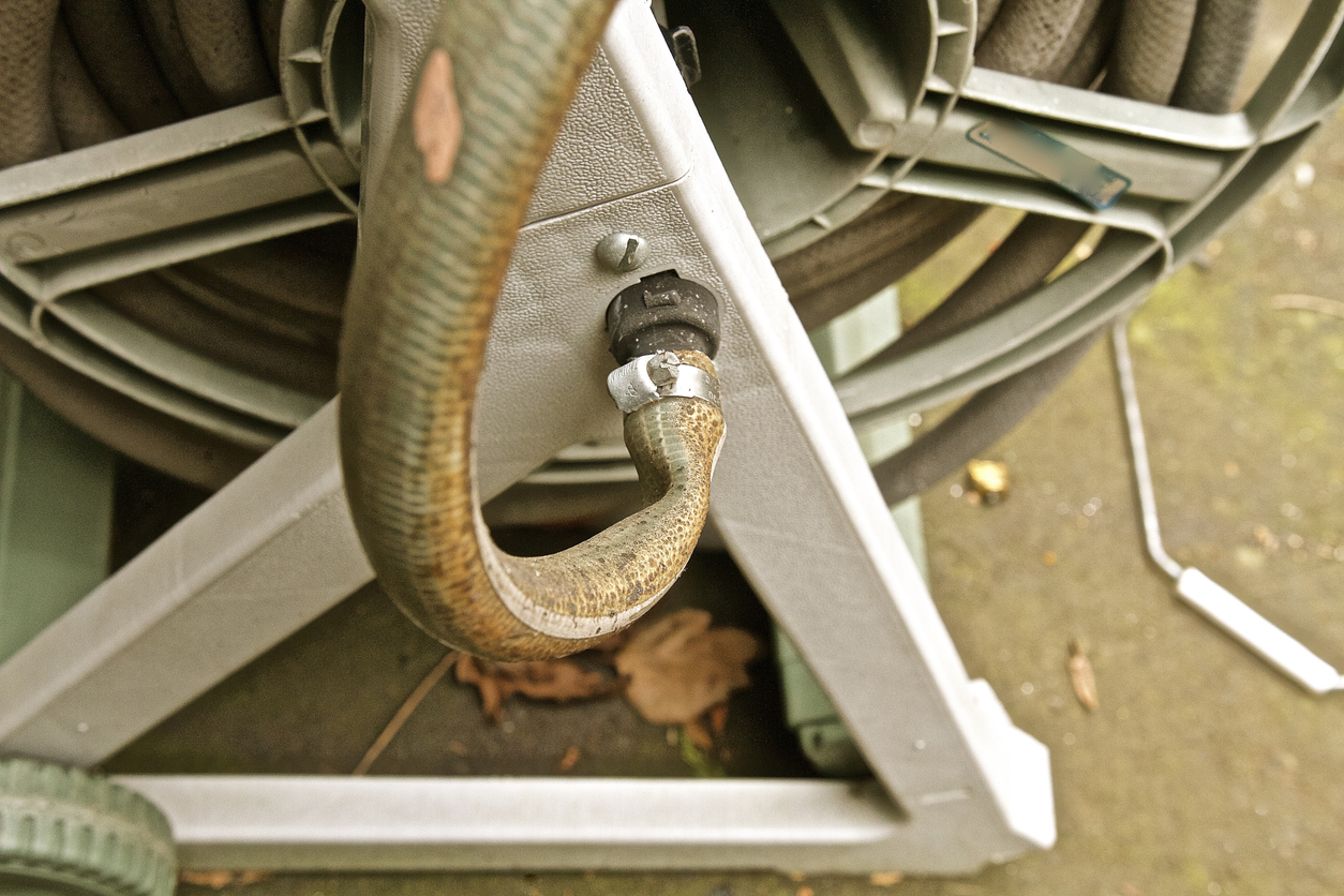 Tuyau ancien plié relié à un enrouleur portable