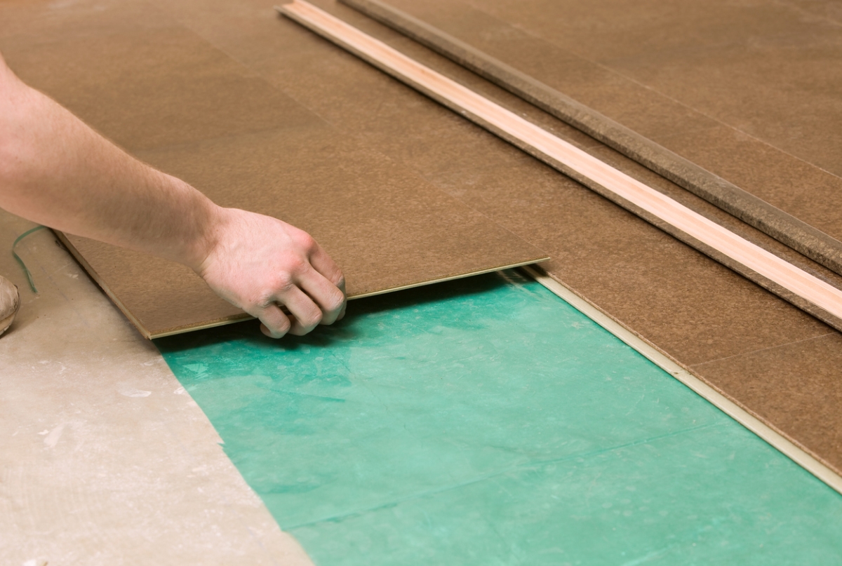 Person putting cork flooring squares on floor