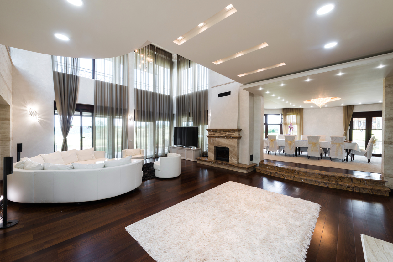 A spacious upscale home interior with a mixture of soft white and daylight recessed lighting in the living room and formal dining room.