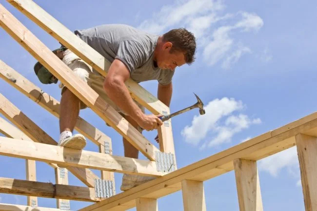 Man nailing framing for a house