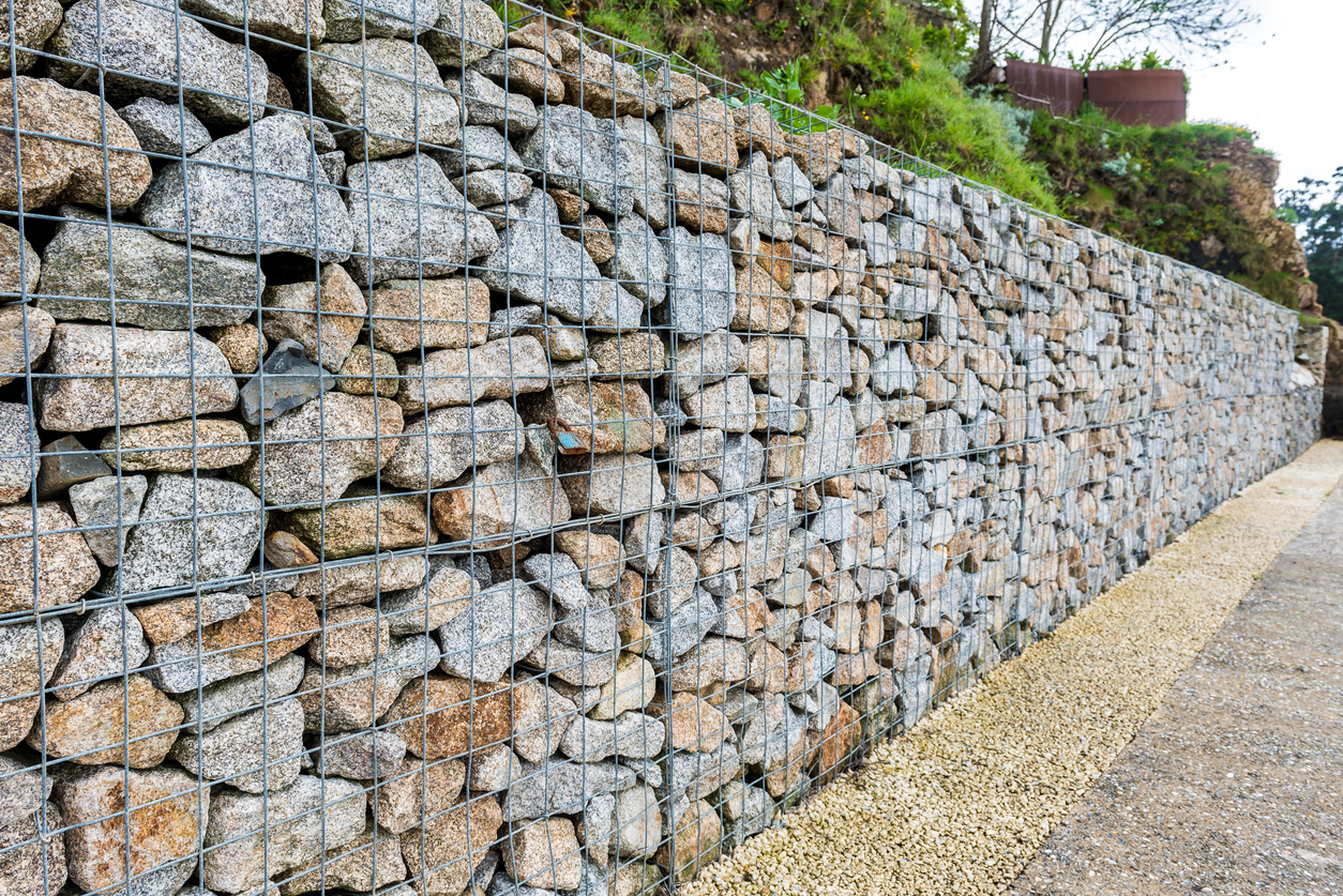 Clôture en gabion métallique. Cage métallique remplie de roches. Texture d'arrière-plan d'une clôture en pierre avec cage.