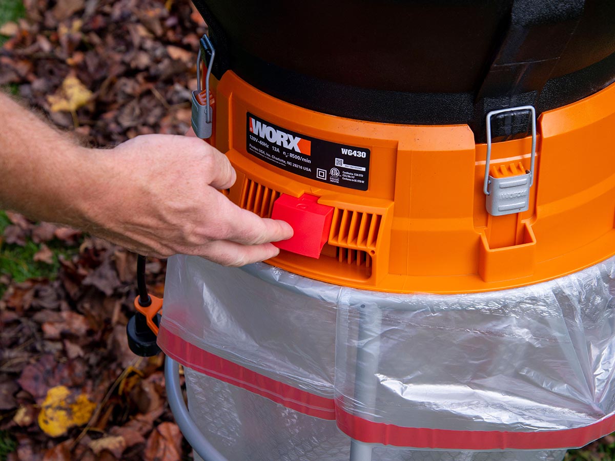 Une personne mettant en marche le broyeur de feuilles Worx